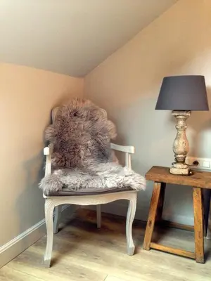a white chair with a furry seat next to a table at B&B Silentium in Tielt