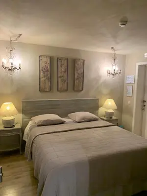 a bedroom with a large bed with two lamps and two tables at B&B Silentium in Tielt
