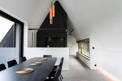 a dining room with a black table and chairs at Holiday Home L'O Reine - with luxury wellness in Sint-Pieters-Leeuw