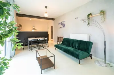 a living room with a green couch and a table at Antwerps Central Residence in Antwerp