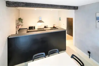 a kitchen with a black counter and a table and chairs at Antwerps Central Residence in Antwerp