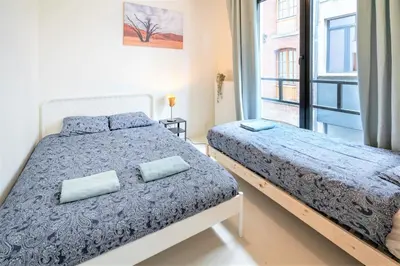 a bedroom with two beds and a window at Antwerps Central Residence in Antwerp