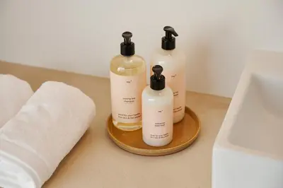 three bottles ofodorizers sitting on a tray in a bathroom at Edgar Guesthouse in Ghent