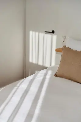 a white bed with a pillow and a window at Edgar Guesthouse in Ghent