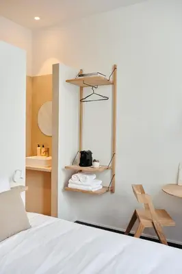 a bedroom with a bed and a chair and shelves at Edgar Guesthouse in Ghent