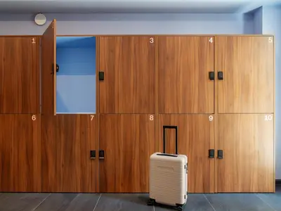 a suitcase sits in front of a row of lockers at YAYS Antwerp Opera by Numa in Antwerp