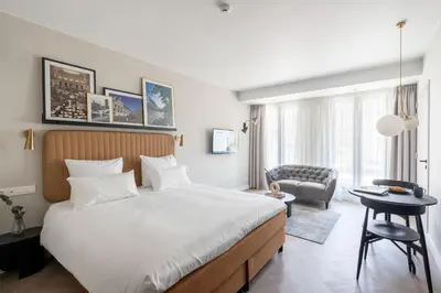 a bedroom with a large bed and a chair at YAYS Antwerp Opera by Numa in Antwerp