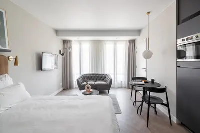 a bedroom with a bed and a table and a couch at YAYS Antwerp Opera by Numa in Antwerp