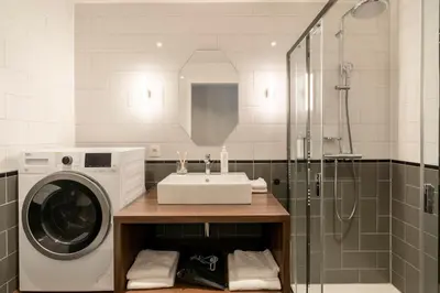 a bathroom with a sink and a washing machine at YAYS Antwerp Opera by Numa in Antwerp