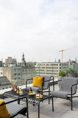 a patio with two chairs and a table on a roof at YAYS Antwerp Opera by Numa in Antwerp