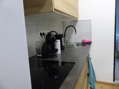 a kitchen with a sink and a black counter top at Superbe Studio au 1er étage, proche de la gare du Midi in Brussels