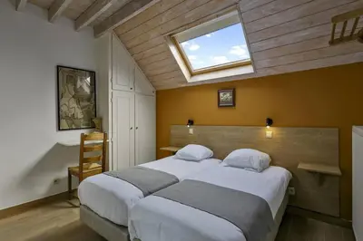 a bedroom with a large bed with a window at Domein Warandehof in Gooik