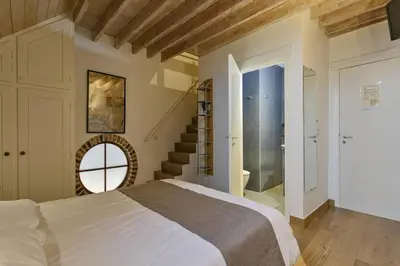 a bedroom with a large bed and a staircase at Domein Warandehof in Gooik