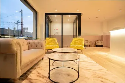 a living room with a couch and a table and chairs at Hôtel Concorde in Brussels