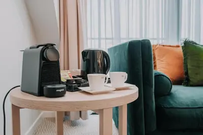 a coffee table with a coffee maker and cups on it at Hôtel Concorde in Brussels