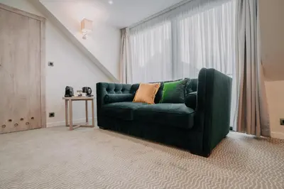 a green couch in a living room with a window at Hôtel Concorde in Brussels