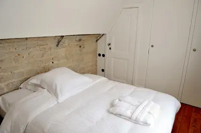 a white bed with two towels on top of it at Guesthouse Bernardin in Antwerp