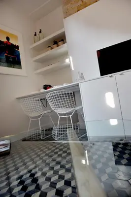 a kitchen with white cabinets and a checkered floor at Guesthouse Bernardin in Antwerp