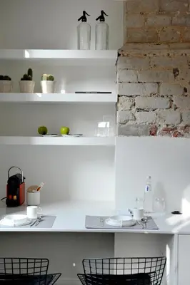 a white kitchen with black chairs and white shelves at Guesthouse Bernardin in Antwerp