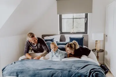 a family is sitting on a bed at Ramslo in Herselt