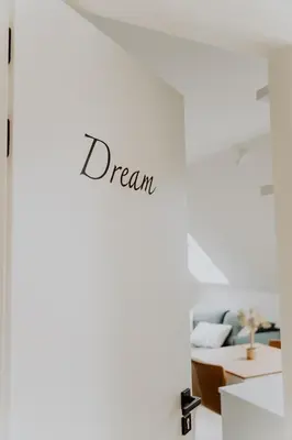 a room with a dream sign on a white wall at Ramslo in Herselt