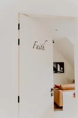 a white door with the word faith written on it at Ramslo in Herselt