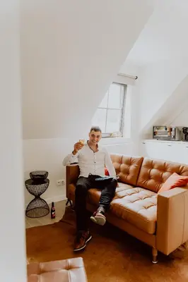 a man sitting on a couch in a living room at Ramslo in Herselt