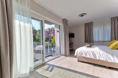 a bedroom with a bed and a large window at BEUKENHOUSE in Drogenbos