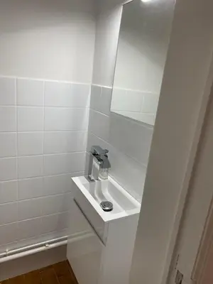 a white bathroom with a sink and a mirror at Lichtrijk mooi appartement met zicht op hof van Roosendael in Antwerp