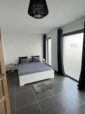 a bedroom with a white bed and a window at FDS Cosy Apartment in Ghent