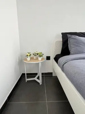 a bedroom with a bed and a table with two plants at FDS Cosy Apartment in Ghent