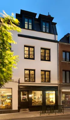 a white building with black windows at La Maison Haute guesthouse in Brussels