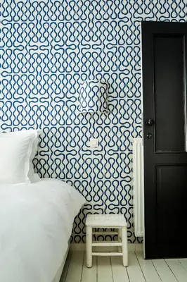 a bedroom with a bed and a blue and white wall at La Maison Haute guesthouse in Brussels