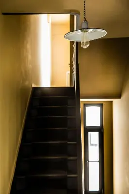 a hallway with a staircase with a chandelier at La Maison Haute guesthouse in Brussels