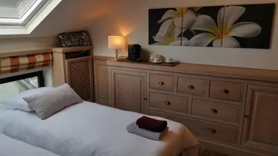 a bedroom with a white bed and a dresser at Lakeview in Keerbergen