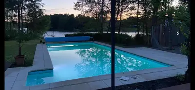 a swimming pool with blue water in a yard at Lakeview in Keerbergen