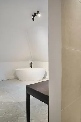 a bathroom with a white tub and a sink at Moleneinde 10 in Weelde