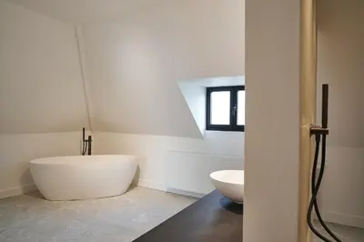 a bathroom with a large white tub and a sink at Moleneinde 10 in Weelde