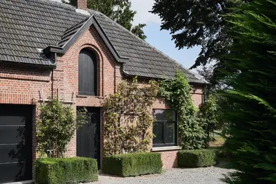 a red brick house with ivy growing on it at Moleneinde 10 in Weelde