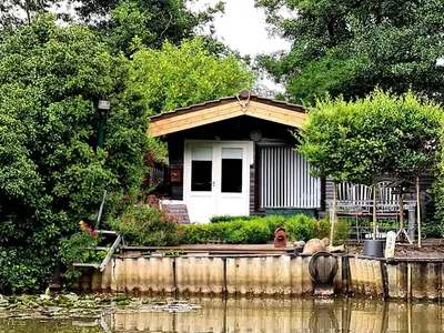 a house with a dog sitting in front of it at Rent & Relax: De steiger in Geel