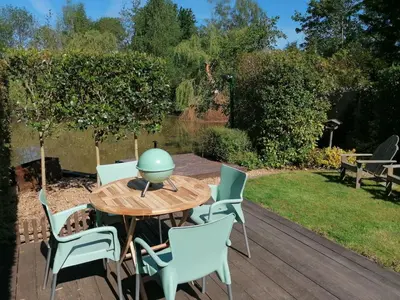 a wooden table and chairs on a wooden deck at Rent & Relax: De steiger in Geel