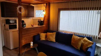 a living room with a blue couch and a window at Rent & Relax: De steiger in Geel