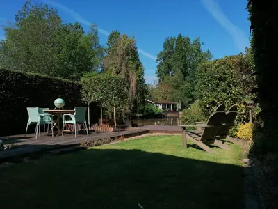 a patio with a table and chairs in a garden at Rent & Relax: De steiger in Geel