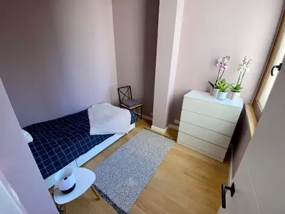 a small room with a bed and a dresser at Appartements Gustav in Brussels