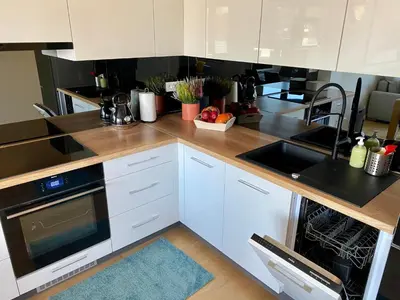 a kitchen with white cabinets and a stove top oven at Appartements Gustav in Brussels