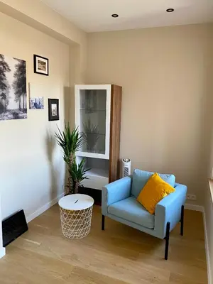 a living room with a blue couch and a table at Appartements Gustav in Brussels