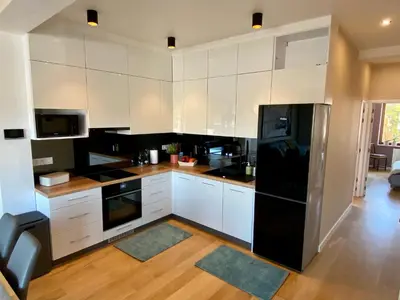 a kitchen with white cabinets and black appliances at Appartements Gustav in Brussels
