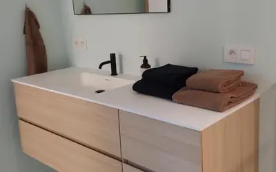 a bathroom with a sink and towels on a counter at B&B Altijd Zomer in Nijlen