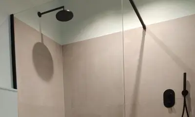a shower with a glass door in a bathroom at B&B Altijd Zomer in Nijlen
