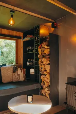 a room with a table and a pile of logs at Tiny House Célestine By Ernesst in Overijse